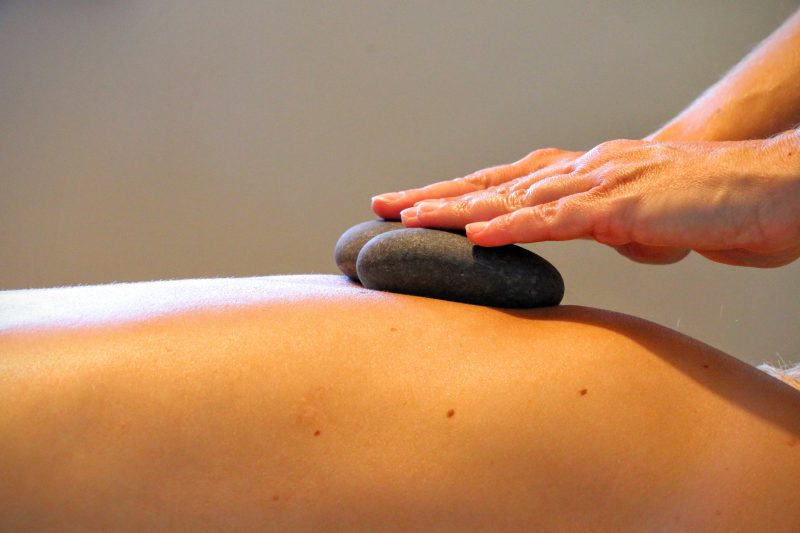 Massage met hete stenen op je rug